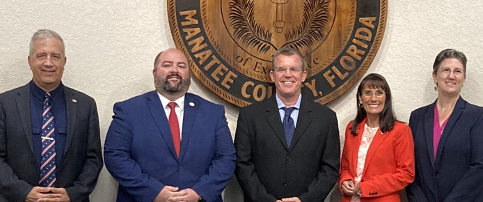 School Board members pose for picture in front of the District seal.
